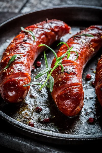 Geroosterde worst met verse rozemarijn op hete barbecue schotel — Stockfoto