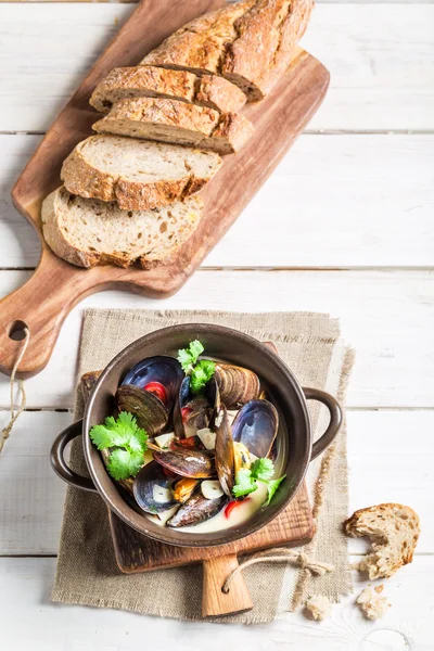 Mosselen met knoflook en rode paprika geserveerd met brood — Stockfoto