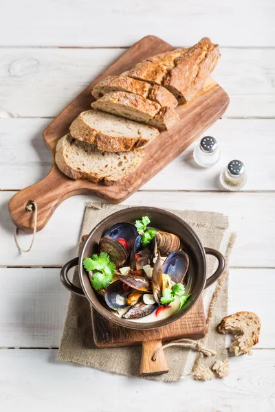 Heerlijke mosselen met knoflooksaus geserveerd met brood — Stockfoto