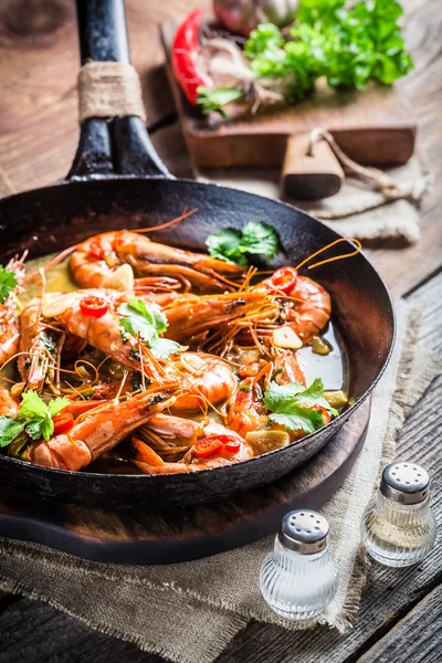 Langostinos fritos con ajo y pimientos rojos —  Fotos de Stock