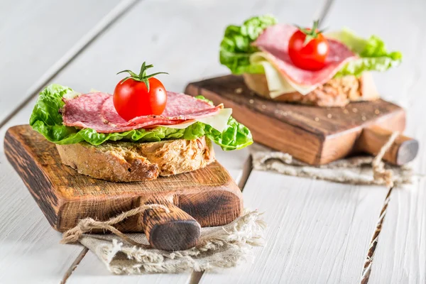 Sandwich gemaakt van salami met sla en tomaat — Stockfoto