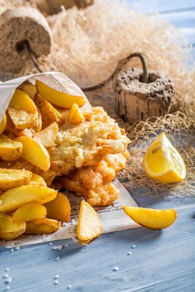 Delicioso bacalao de pescado con patatas fritas en el periódico — Foto de Stock