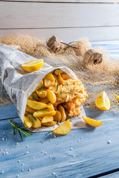 Hot fish cod with chips in newspaper with lemon — Stock Photo, Image