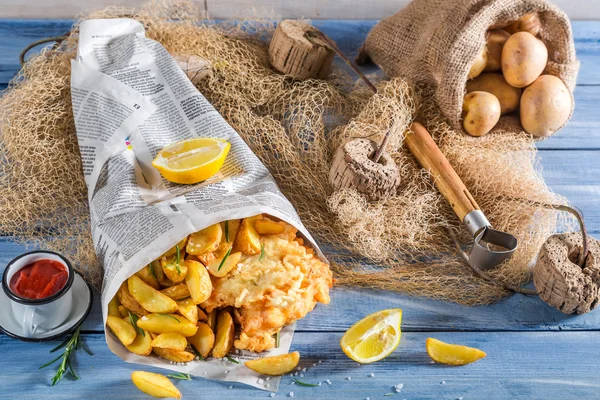 Baccalà di pesce saporito con patatine fritte in giornale con limone — Foto Stock