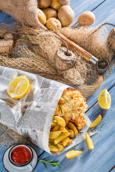 Pesce fresco e patatine fritte servite in carta con limone — Foto Stock