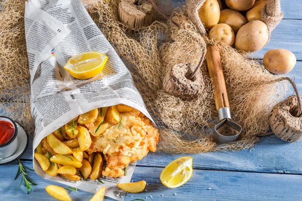 Pesce fresco e patatine fritte nel giornale con limone — Foto Stock