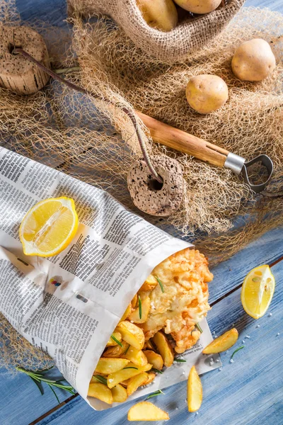 Peixe caseiro e batatas fritas em jornal com limão — Fotografia de Stock