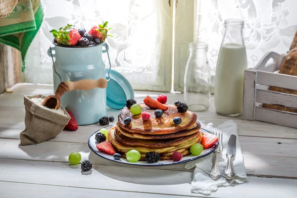 Delicious pancakes with fruits and maple syrup — Stock Photo, Image
