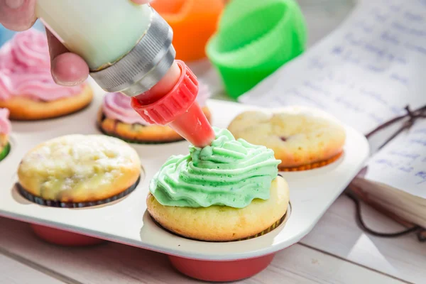 Decorating sweet cupcakes with cream and decoration — Stock Photo, Image