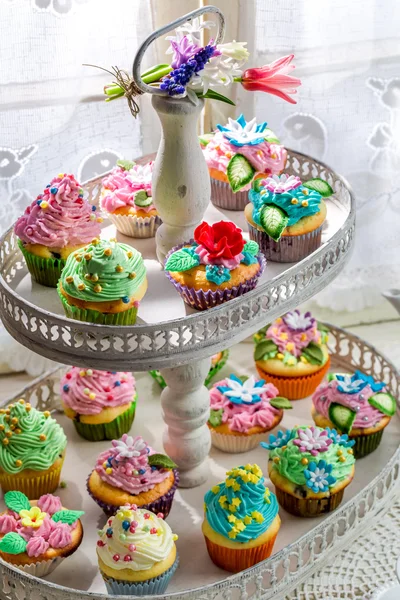 Tasty muffins with sweet decoration and cream — Stock Photo, Image
