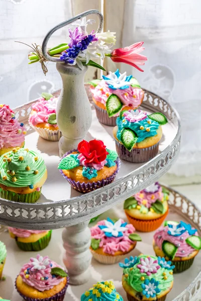 Tasty cupcakes with sweet decoration and cream — Stock Photo, Image