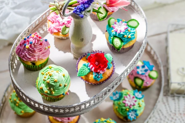 Sweet muffins with sweet decoration and cream — Stock Photo, Image