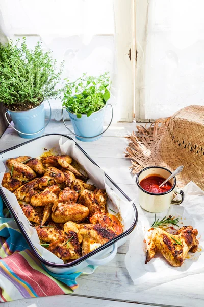 Asas de frango quentes com ervas e molho na cozinha de verão — Fotografia de Stock