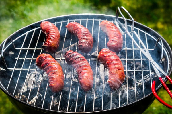 Červené horké párky s rozmarýnem na grilu — Stock fotografie