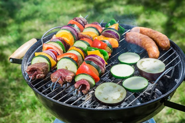 Roasting fresh vegetables and red beef with herbs in garden — Stock Photo, Image