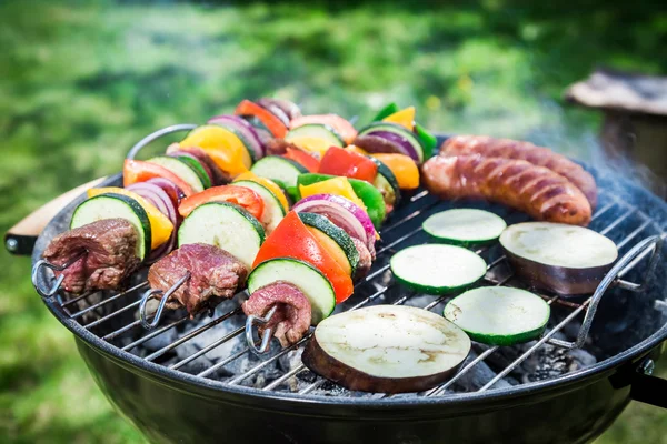 Braten von frischem Gemüse und rotem Rindfleisch mit Gewürzen im Garten — Stockfoto