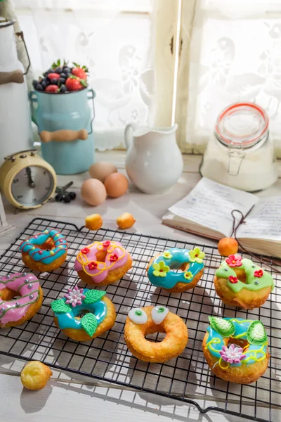 Décorer des beignets savoureux dans la cuisine ensoleillée — Photo