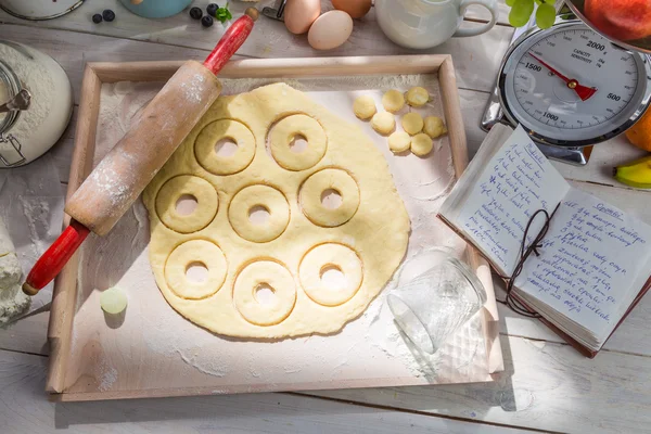 Assar donuts caseiros na cozinha ensolarada — Fotografia de Stock