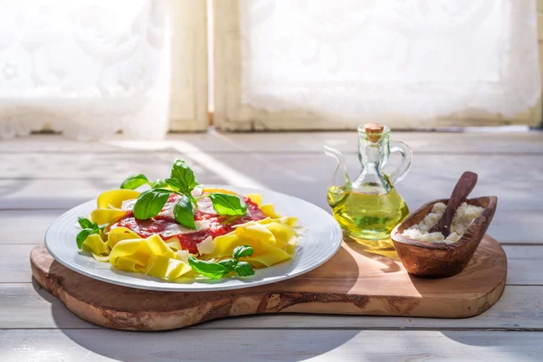 Makaron Pappardelle z pomidorami, bazylią i parmezan w słonecznej kuchni — Zdjęcie stockowe
