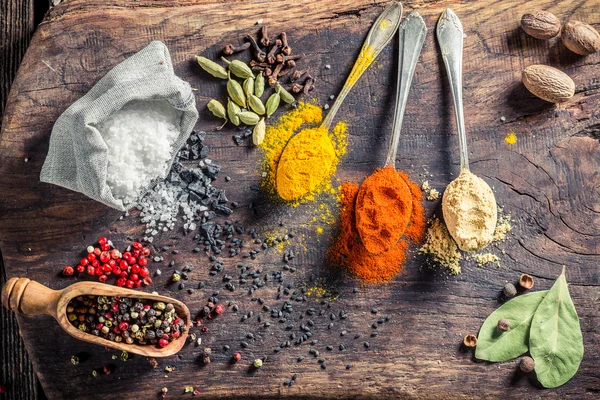 Colorful herbs and spices on old board — Stock Fotó
