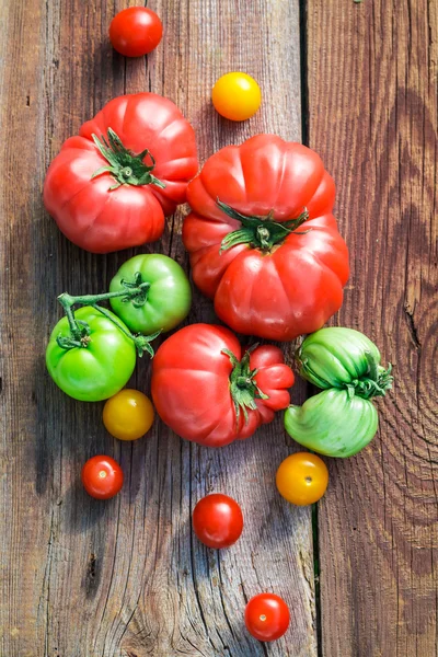 Ripe tomatoes on old wooden table — Stock Photo, Image