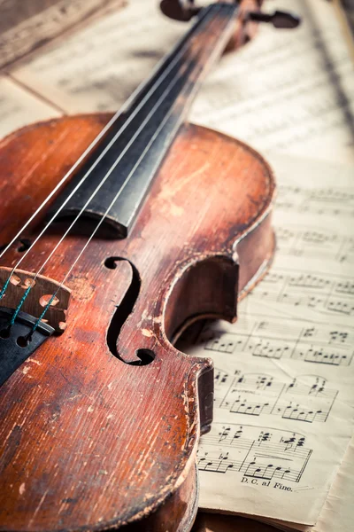 Hojas musicales antiguas y violín sobre mesa de madera vieja — Foto de Stock
