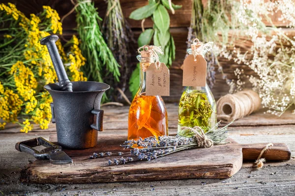 Homemade herbs in bottles with herbs and alcohol — Stock Photo, Image