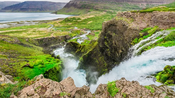 Wasserfall fließt in ein Tal in Island — Stockfoto