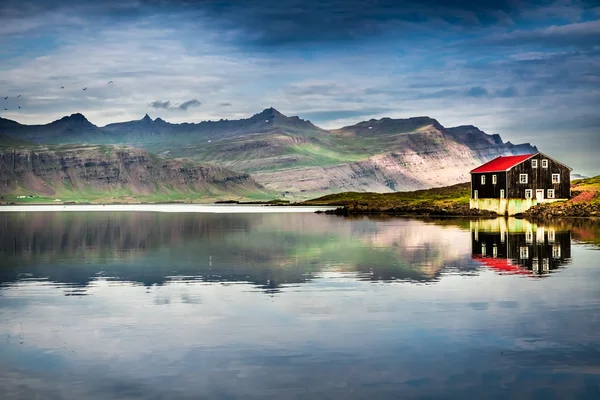 Pequena casa na margem do rio na Islândia — Fotografia de Stock