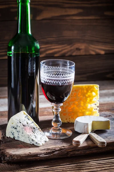 Vinho tinto fresco com vários queijos — Fotografia de Stock