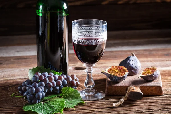 Vinho tinto em vidro e uvas — Fotografia de Stock