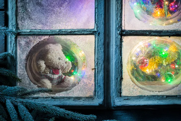 Beautiful teddy bear in frozen window for Christmas — Zdjęcie stockowe