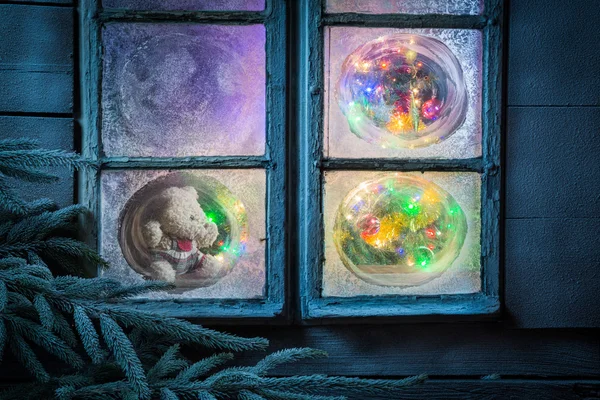 Красивий плюшевий ведмідь на Різдво в замерзлому вікні — стокове фото