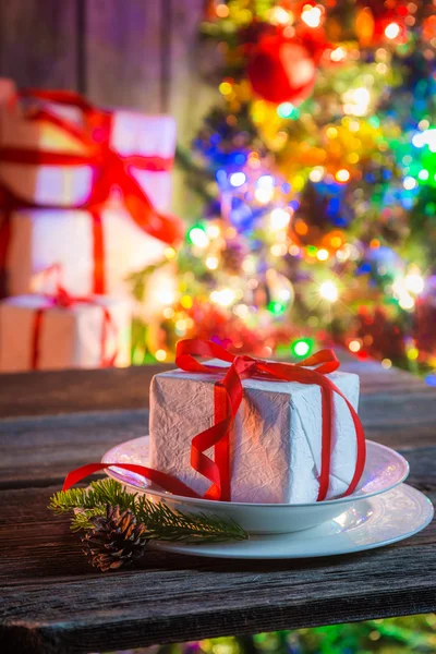 Weihnachtsgeschenk mit Baum und Lichtern im Hintergrund — Stockfoto