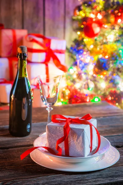 Precioso regalo de Navidad con árbol y luces en el fondo — Foto de Stock