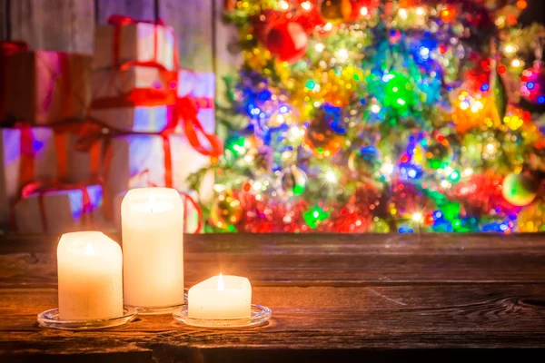 Queimando velas e árvore de Natal com presentes no fundo — Fotografia de Stock