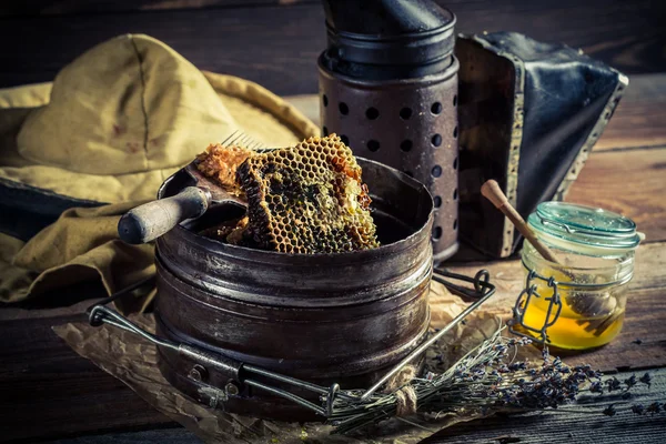 Age beekeeper tools with honey — Stock Photo, Image