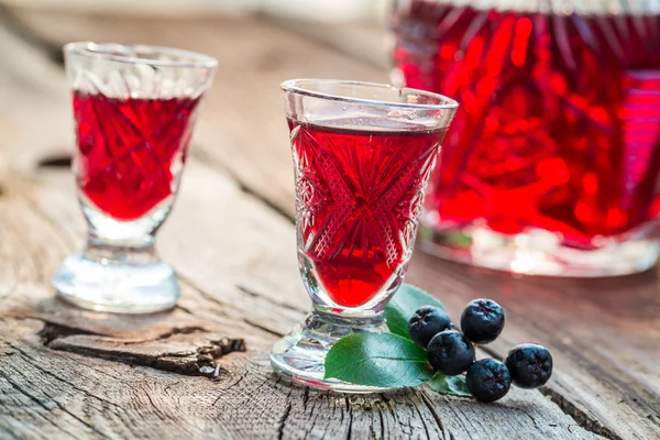 Homemade liqueur with chokeberries and alcohol — Stock Photo, Image