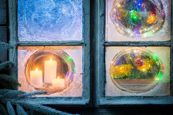 Hermosas velas encendidas para Navidad en ventana congelada —  Fotos de Stock