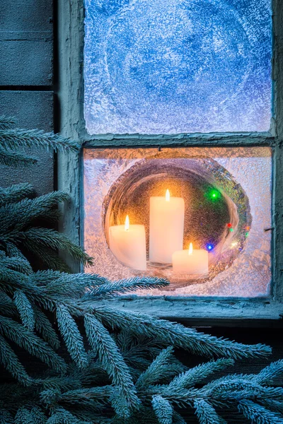 Adorables velas encendidas para Navidad en ventana congelada —  Fotos de Stock