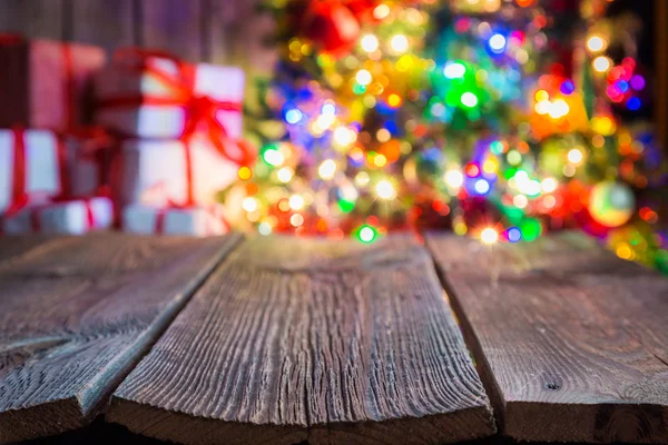 Fondo de Navidad con mesa de madera vieja, bokeh luz y regalos . — Foto de Stock