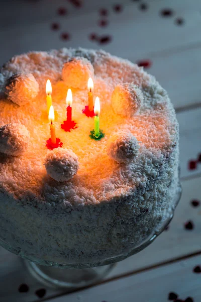 Lighted candles on the cake coconut — Stock Photo, Image