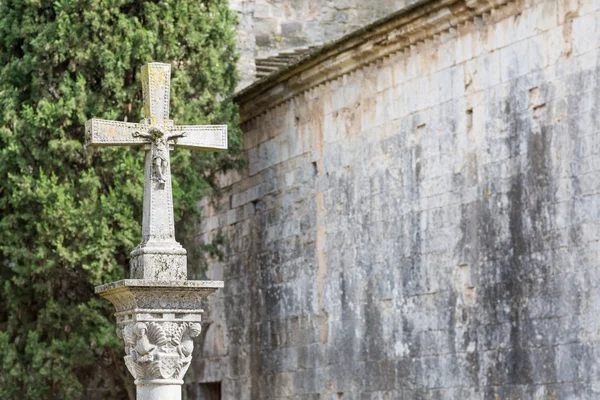 Cruz de pedra com Cristo na frente de uma parede medieval — Fotografia de Stock