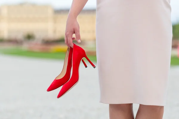 手に赤いハイヒールの靴を持ったエレガントな女性 — ストック写真