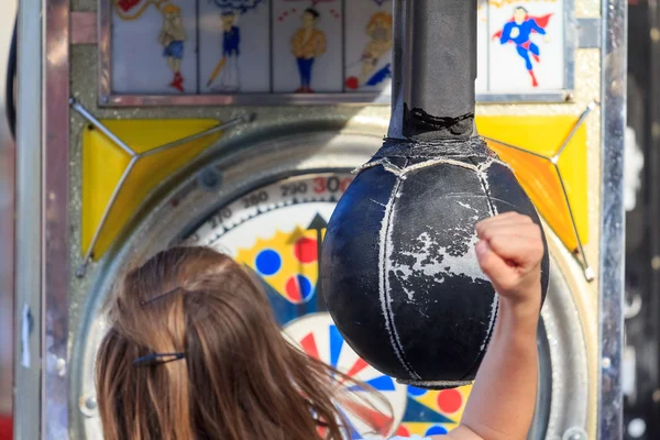 Uma menina batendo um saco de soco de feiras — Fotografia de Stock