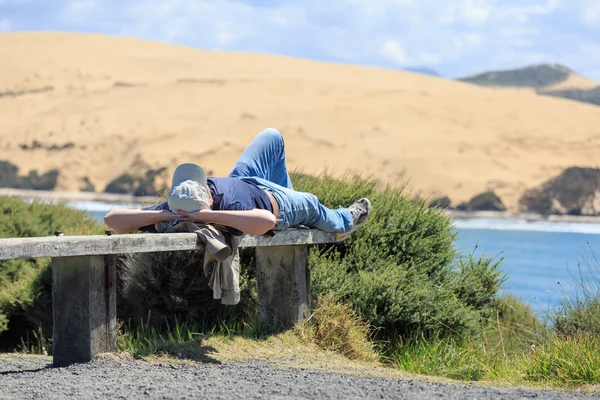 Uomo sdraiato e rilassante su una panchina — Foto Stock