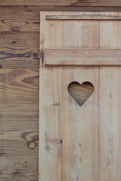 Fönsterrullgardinen av en trähytt med ett hjärtformat hål — Stockfoto
