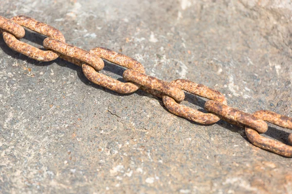 生锈的铁链在一块岩石上 — 图库照片
