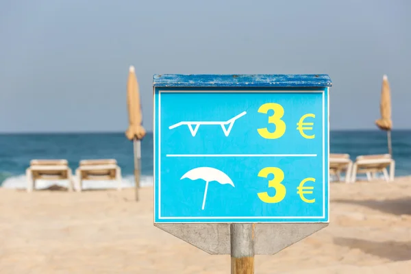 Firma per il prezzo di sedie a sdraio e ombrelloni in spiaggia — Foto Stock