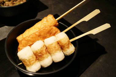 Oden, işlenmiş balık köftesi, soya aromalı Dashi çorbası, siyah kasede servis ediliyor. Japon geleneksel yemekleri